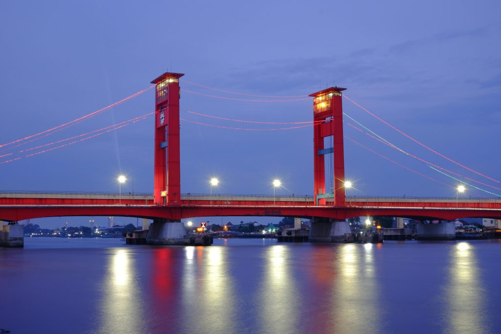 Stunning night view of Ampera Bridge in Palembang, Indonesia with beautifully reflected lights.